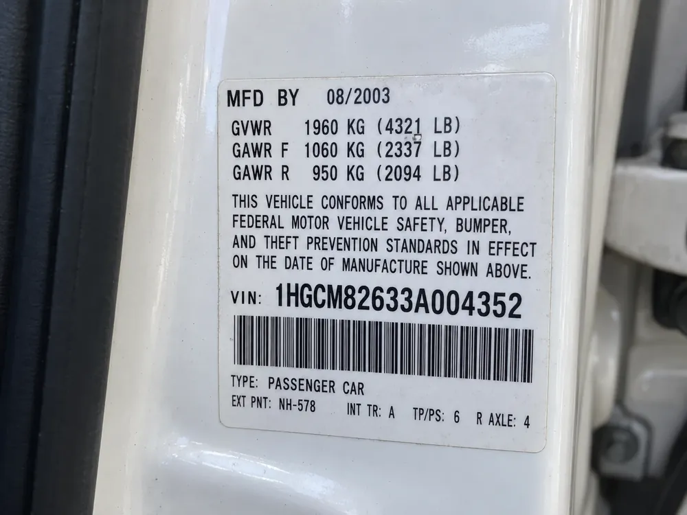 Door-jamb sticker with the 17-character VIN printed above a barcode